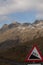 Vertical shot of road sign with hill incline under cloudy sky