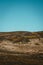 Vertical shot of rocky hillsides under a bright sky