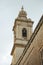 Vertical shot of the roof of the bell tower of an old cathedral made of white bricks