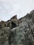 Vertical shot of rough rocky cliffs under a cloudy sky