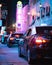 Vertical shot of a row of taxis on the street with a neon light in the background in Macau