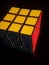 Vertical shot of Rubik\'s cube isolated on a black background
