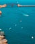 Vertical shot of the sea and boats with St Elmo Bridge in the background. Malta.