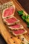 Vertical shot of Sesame crusted yellowfin tuna steak on wooden board