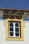 Vertical shot of several bird nests above the window on a colorful house