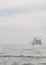 Vertical shot of a ship with sails sailing across the ocean