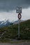 Vertical shot of sign post at Col of Croix de Coeur with bench and dark Clouds