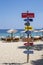 Vertical shot of signs showing directions of different countries in Koukounaries Beach, Greece