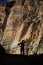 Vertical shot of a silhouette of a person looking at the rocky cliffs of Zion National Park