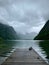 Vertical shot of sleeping ducks on a wooden dock at Lake Konigssee with cloudy sky and hills