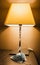 Vertical shot of a small bedside lamp on a table with a facemask on it - COVID-19