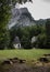 Vertical shot of a small cottage surrounded with green trees in Vrata valley, Triglav National Park