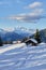 Vertical shot of the small huts nestled between the snowy mountains