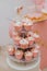 Vertical shot of small pink cupcakes for a birthday party on a three-tiered tray