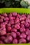 Vertical shot of small red potatoes in a green plastic basket in a market