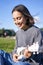 Vertical shot of smiling asian girl singing and laughing, playing ukulele, learn how to play instrument, sitting