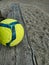 Vertical shot of a soccer ball on a wooden bench in a park