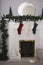 Vertical shot of socks hung from a green chain and the golden fireplace