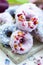Vertical shot of some purple and blue vegan donuts covered with edible rose flowers