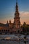 Vertical shot of the South tower of Plaza Spain with people in the square in the foreground