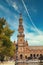 Vertical shot of the South tower of Plaza Spain with people visitors in the foreground