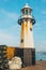 Vertical shot of St Ives harbor lighthouse with sea and sky in the background