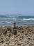 Vertical shot of a stack of pebbles on the seacoast under a blue clear sky