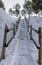 Vertical shot of stairs of a hiking trail covered by snow