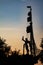 Vertical shot of a statue of a captain on a sailing boat during a beautiful sunset