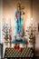 Vertical shot of a statue of Saint Mary holding infant Jesus with illuminated candles