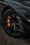 Vertical shot of the stylish rims of a luxurious black McLaren automobile