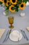 Vertical shot of sunflower decorations, cutlery, and a tea cup on a table