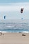 Vertical shot of the sunny Playa del Guincho with people parachuting in the sea, Portugal