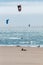 Vertical shot of the sunny Playa del Guincho with people parachuting in the sea, Portugal