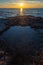 Vertical shot of the sunset over rock formations in the Adriatic sea in Savudrija, Istria, Croatia