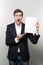 Vertical shot of a surprised male pointing to a blank paper that he is holding