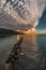 Vertical shot of swan near water breakers during a breathtaking sunset