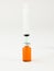Vertical shot of a syringe getting liquid from an orange medicine bottle