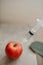 Vertical shot of a syringe injected into an apple