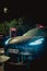 Vertical shot of a Tesla car charging at supercharger at night under the rain