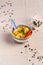 Vertical shot of a Thai pasta soup served in a bowl surrounded by spilled pepper seeds