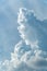 Vertical shot of towering cumulus clouds on blue sky background
