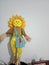 Vertical shot of a toy scarecrow with sunflower-shaped head