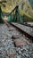 Vertical shot of train tracks near cliffs with an illuminated train approaching