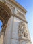 Vertical shot of triumphal arch and a detailed depiction of architectural design and angels' statues