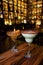 Vertical shot of two fruity alcoholic beverages on a wooden table at a nightclub