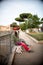 Vertical shot of two transparent dolls placed on a wooden bench on the streets of Rome