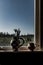 Vertical shot of two vases near the window filled with art supplies with the background of daylight