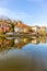 Vertical shot of vibrant buildings reflecting in the river in Schmalkalden, Germany during spring