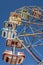 Vertical shot of a vibrant Ferris wheel against a vivid blue sky in summer